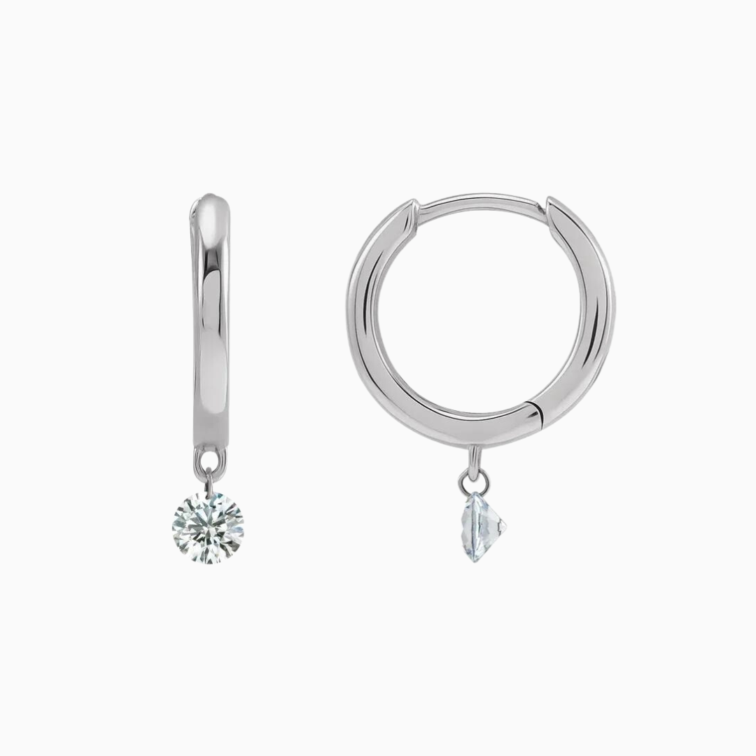 The perfect every day hoops with just the right amount of sparkle! These special earrings feature a dangling natural diamond that's drilled right into the diamond helping it appear as if it's floating.