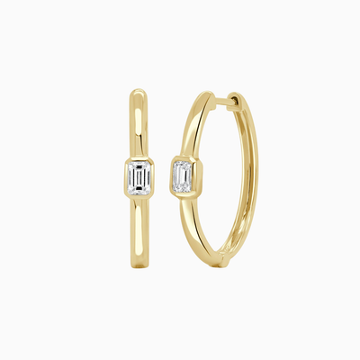 Gold hoop earrings with emerald-cut gemstones on a white background