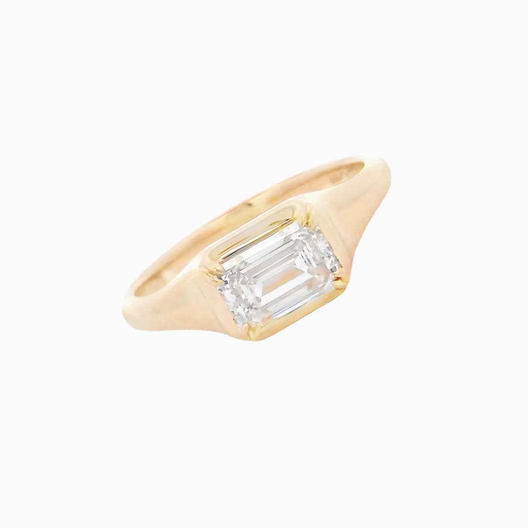 Gold ring with a rectangular diamond on a white background