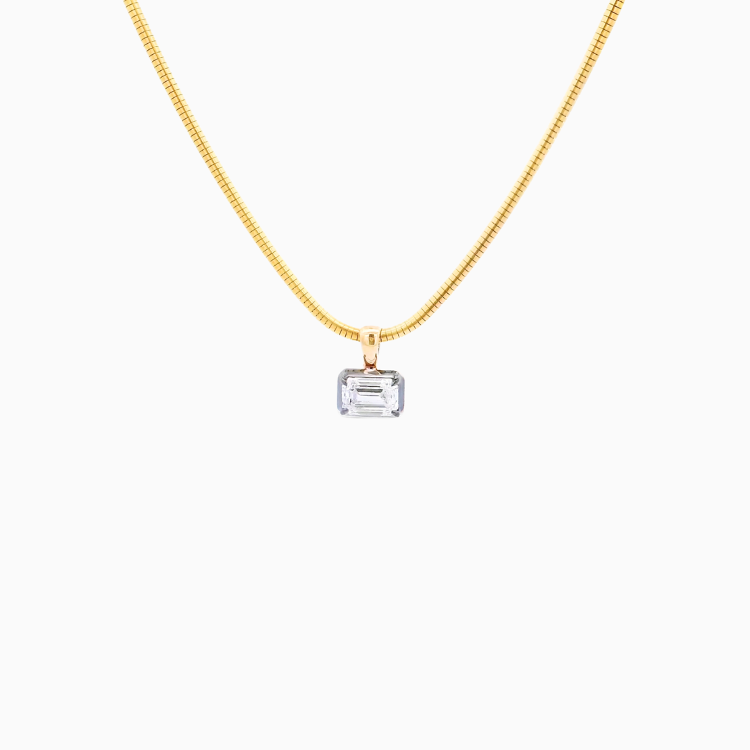 Gold necklace with a rectangular pendant on a white background