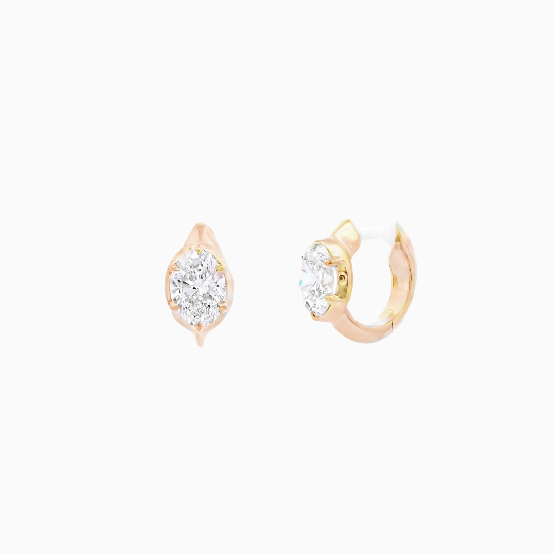 Pair of gold hoop earrings with clear gemstones on a white background