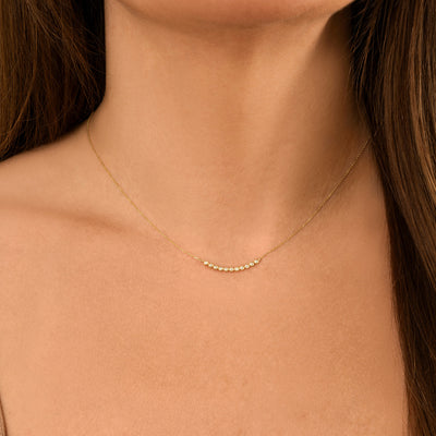 Grace your neckline with effortless sparkle. This necklace features a curved line of bezel-set diamonds, blending simplicity and sophistication. Whether layered or worn alone, it’s the perfect finishing touch for any outfit—day or night.