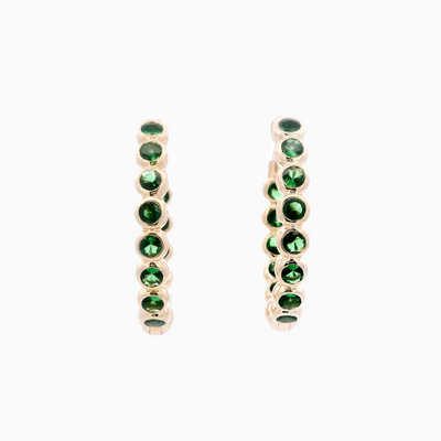 Pair of gold earrings with green gemstones on a white background