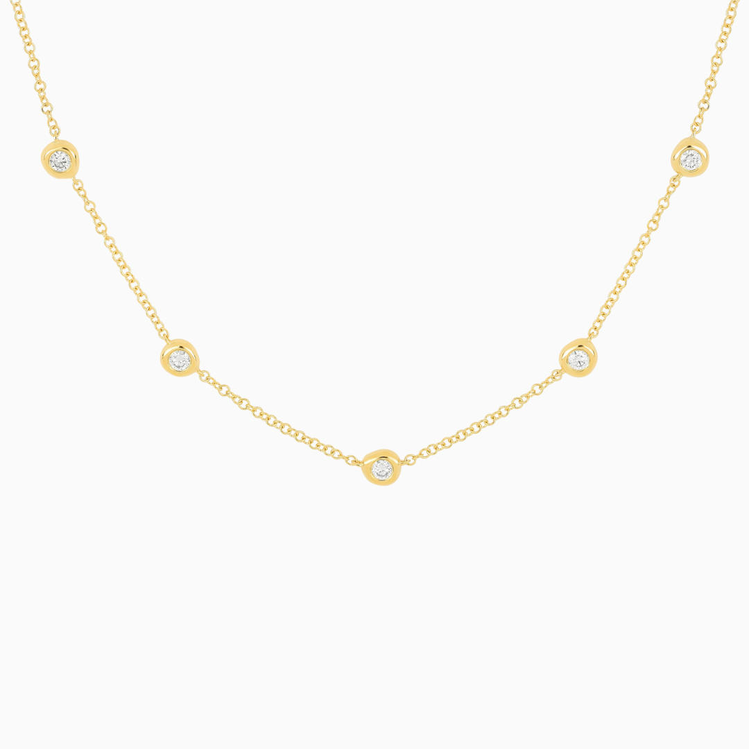 The 5 Diamond Pillow Necklace features five bezel-set diamonds set on a delicate cable chain.  The sculptural bezel setting is a unique design element that gives the gold surrounding these diamonds an organic look, like fluffed pillows.