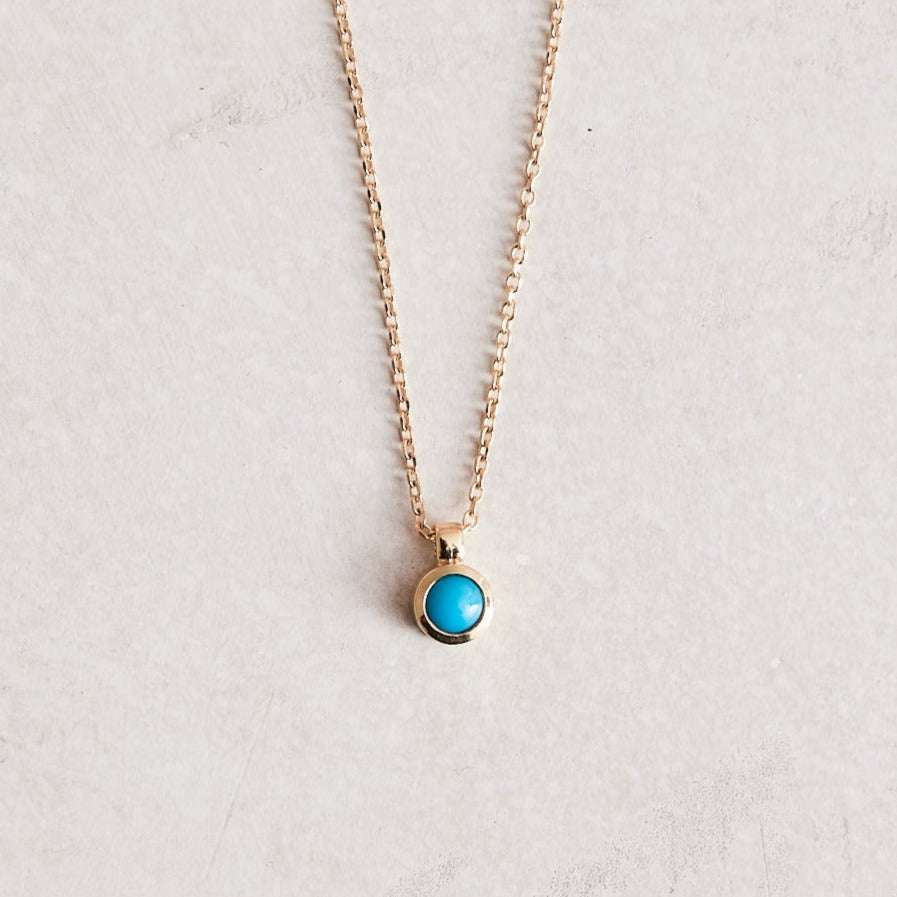 16-18" adjustable 14k gold chain with a bezel-set natural turquoise pendant.