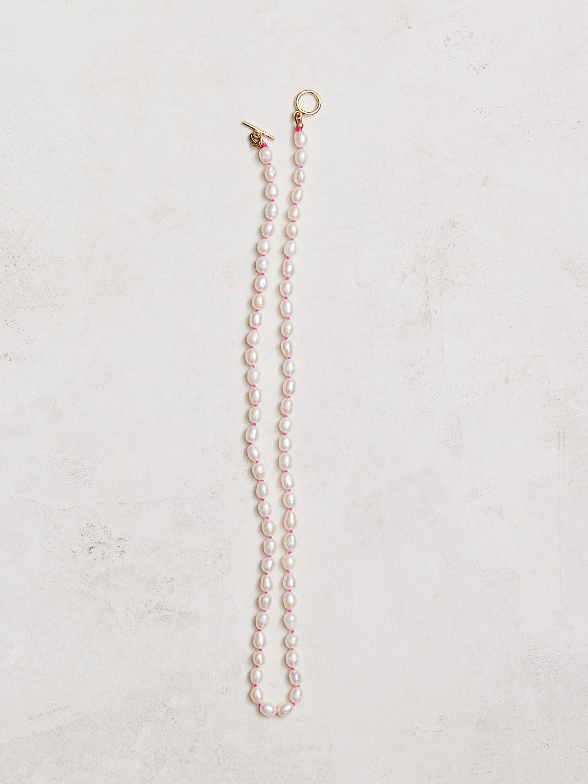 16.5" freshwater pearls hand-knotted on hand-dyed neon silk, gold-filled toggle clasp.  Handmade by Nicole Gerulat.