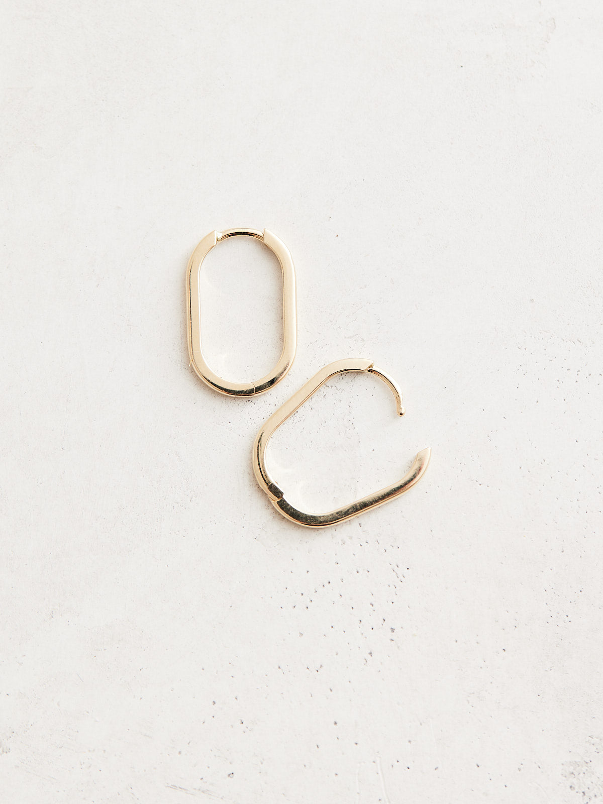 Elongated 14k gold oval huggie hoop earrings