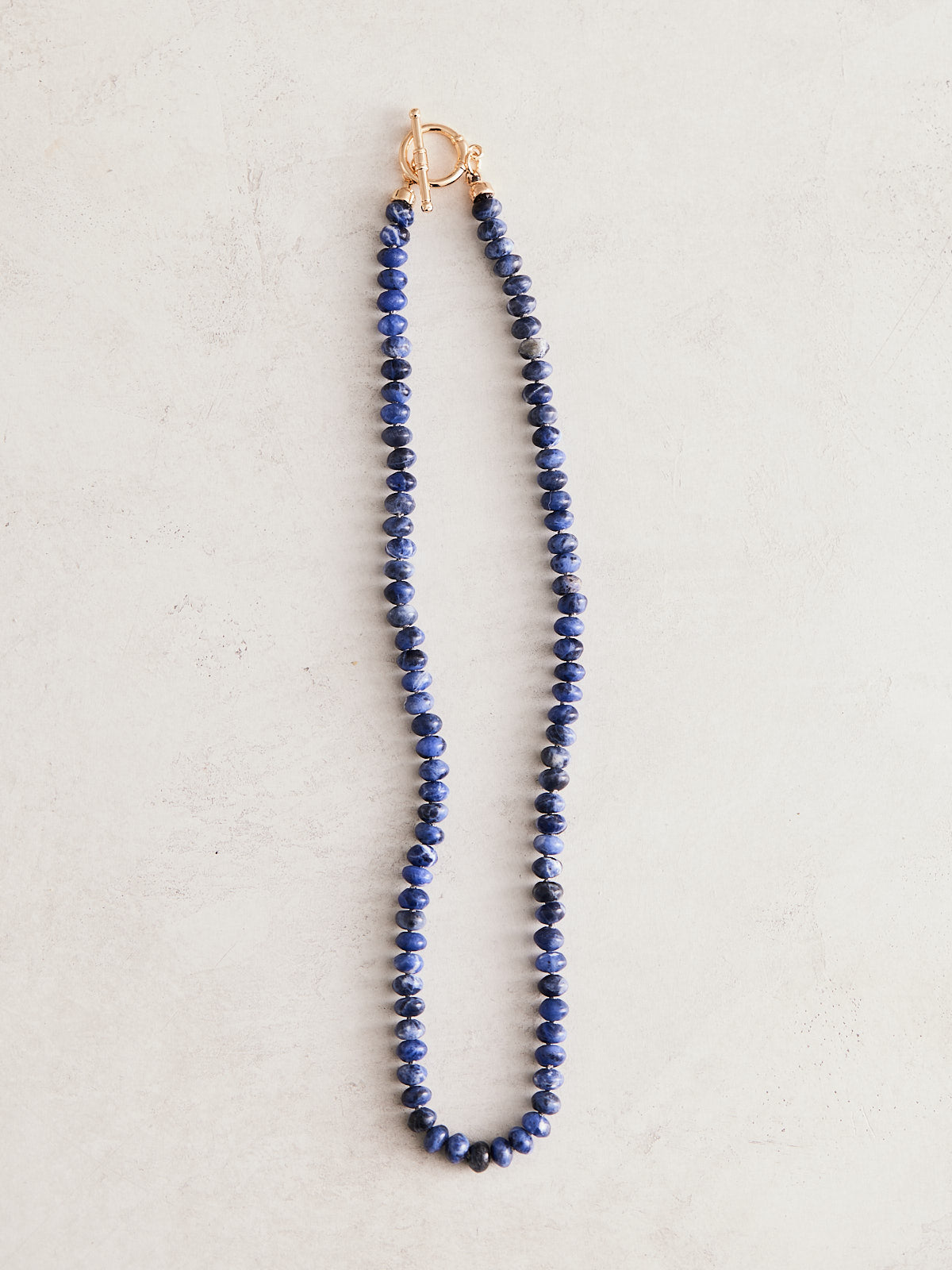 17" natural blue lapis necklace hand-knotted on gray silk with gold-filled findings and toggle clasp. Handmade by Nicole Gerulat.