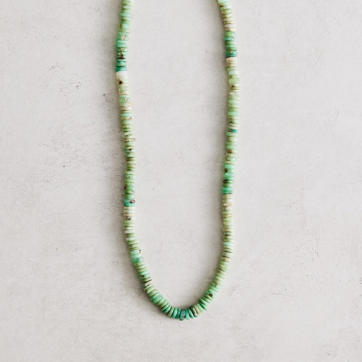 This necklace is 17" long and features natural chrysoprase heishi beads handcrafted by Nicole Gerulat. It is strung on ivory silk with gold filled findings and a lobster clasp.