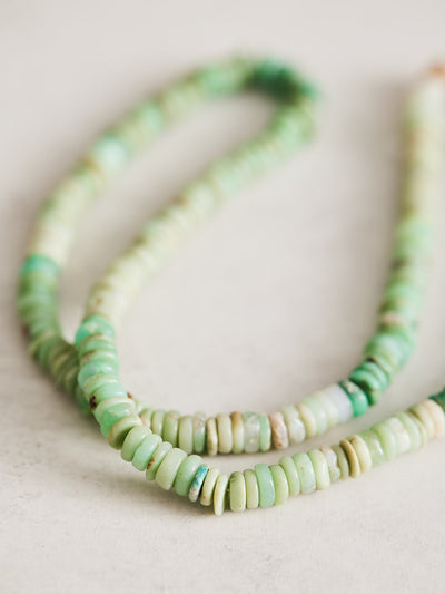 This gemstone necklace is 17" long and features natural chrysoprase heishi beads handcrafted by Nicole Gerulat. It is strung on ivory silk with gold filled findings and a lobster clasp.