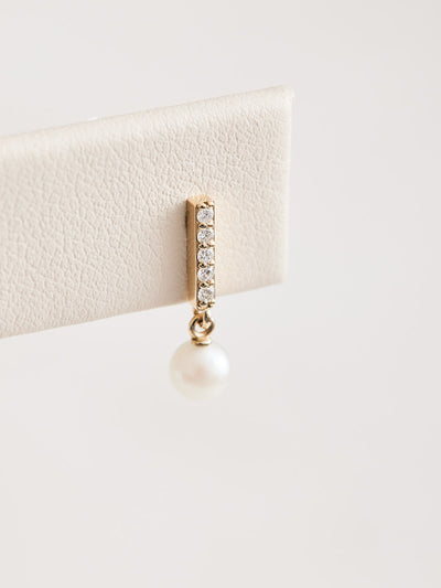 Constructed from 14k gold, these diamond bar earrings boast a cultured akoya pearl drop and .03 CTW of natural diamonds. Choose from yellow, white, and rose gold.