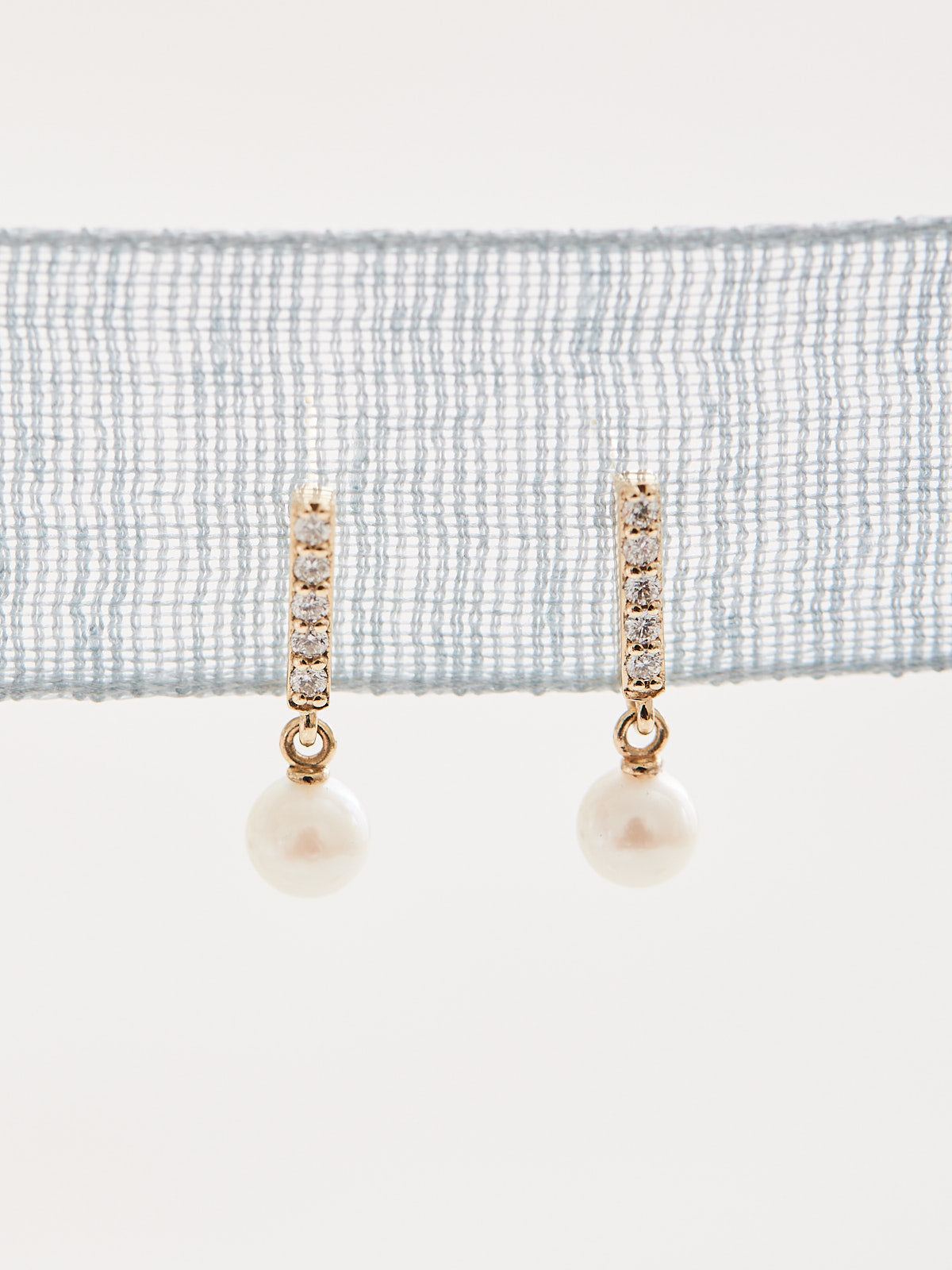 Constructed from 14k gold, these diamond bar earrings boast a cultured akoya pearl drop and .03 CTW of natural diamonds. Choose from yellow, white, and rose gold.