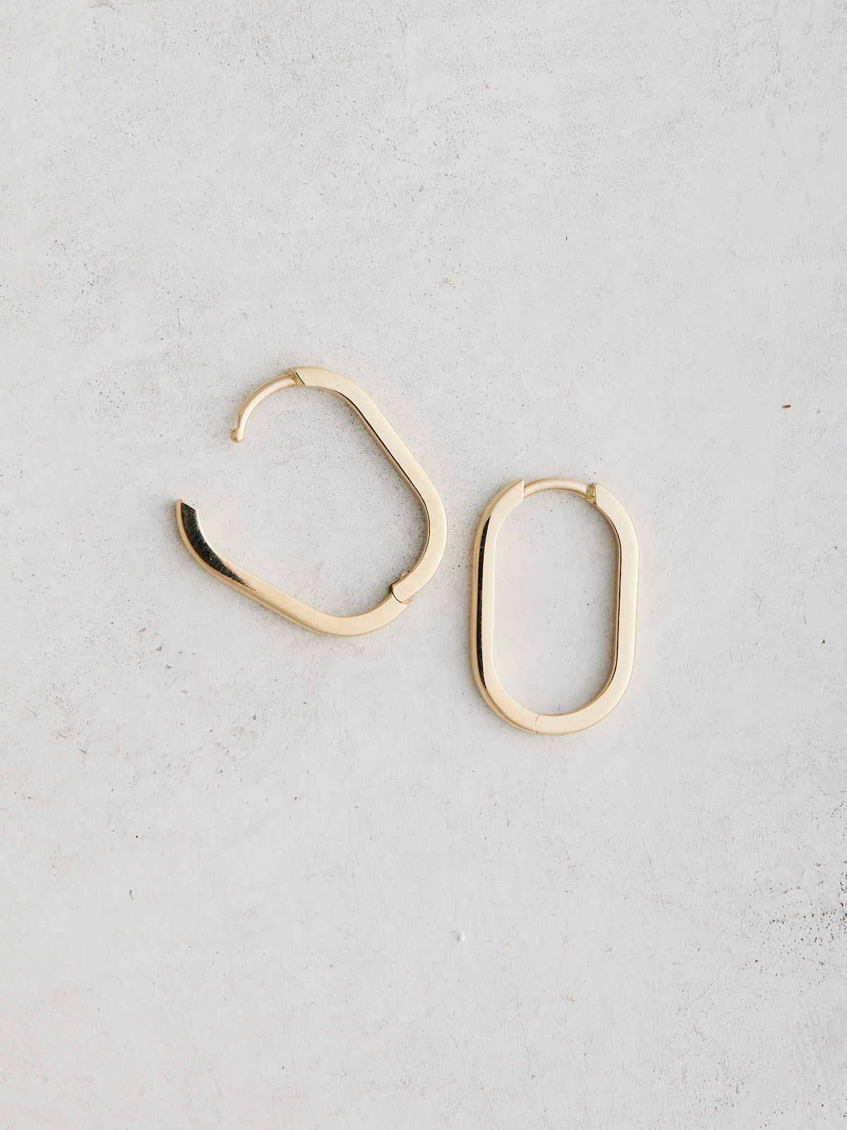 Elongated 14k gold oval huggie hoop earrings