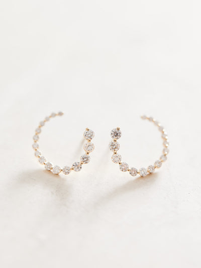 These front-back diamond earrings have 7/8 ctw natural diamonds set in 14k gold. The graduated end tucks behind the lobe for a beautiful illusion of a completed circle that stays facing front. 15mm. Available in white, yellow and rose gold.