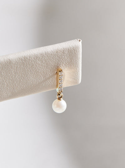 Constructed from 14k gold, these diamond bar earrings boast a cultured akoya pearl drop and .03 CTW of natural diamonds. Choose from yellow, white, and rose gold.