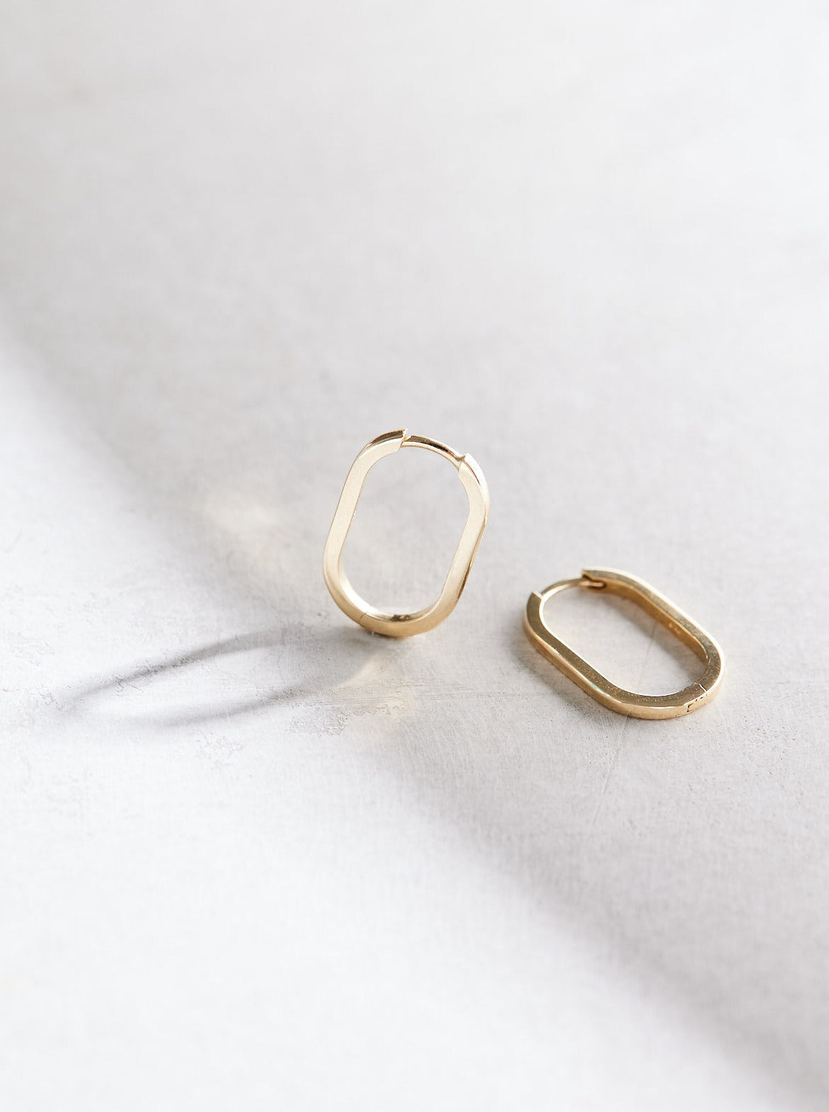 Elongated 14k gold oval huggie hoop earrings